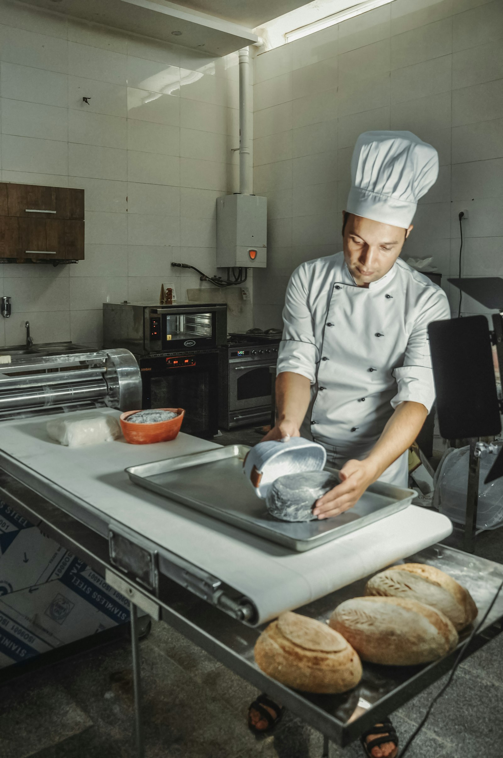 Baker piping cream into choux buns