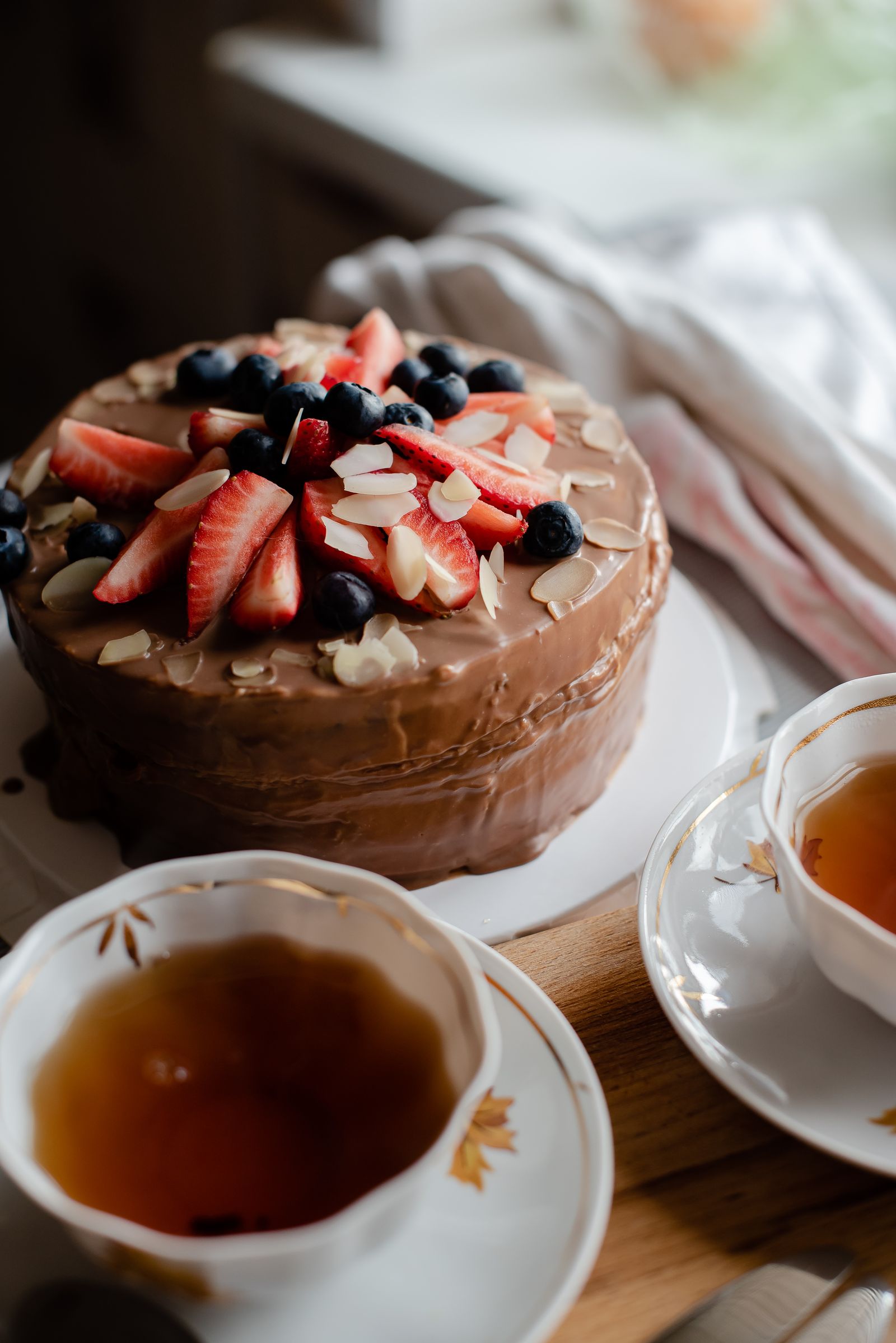 Whole chocolate celebration cake finished with berries and almonds