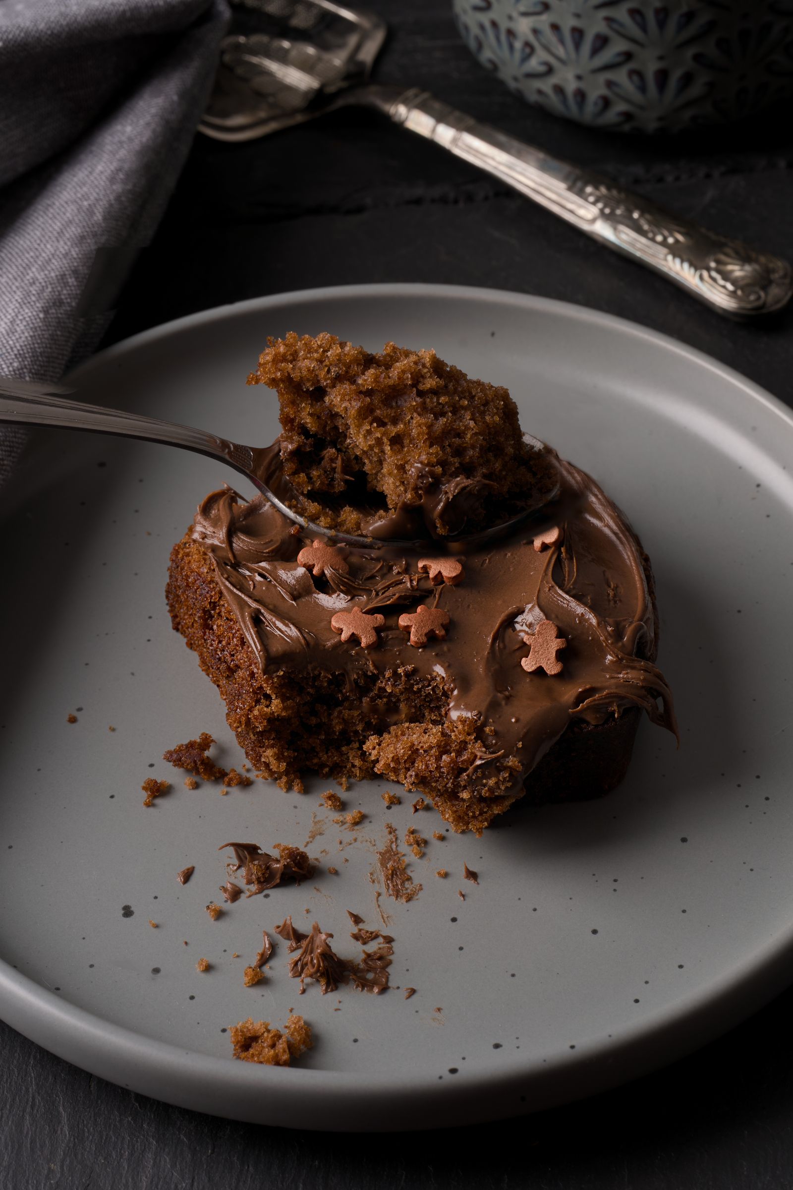 Rich chocolate cake slice with ganache and a spoon