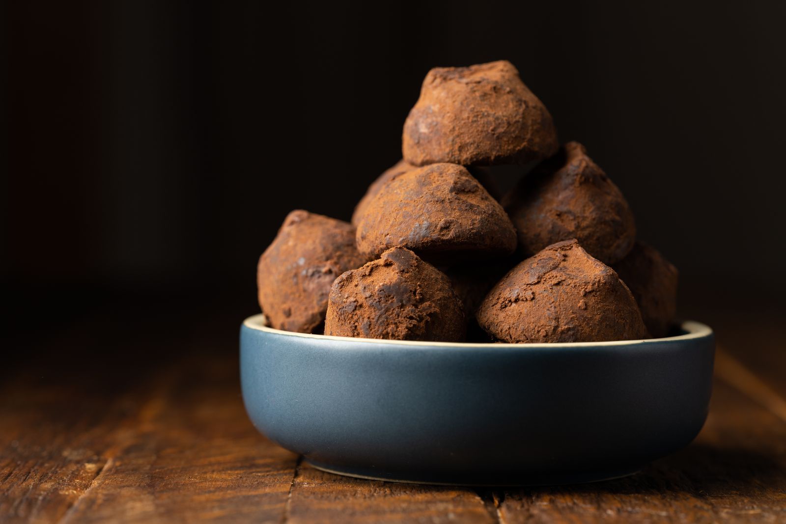 Cocoa-dusted chocolate truffles stacked in a bowl